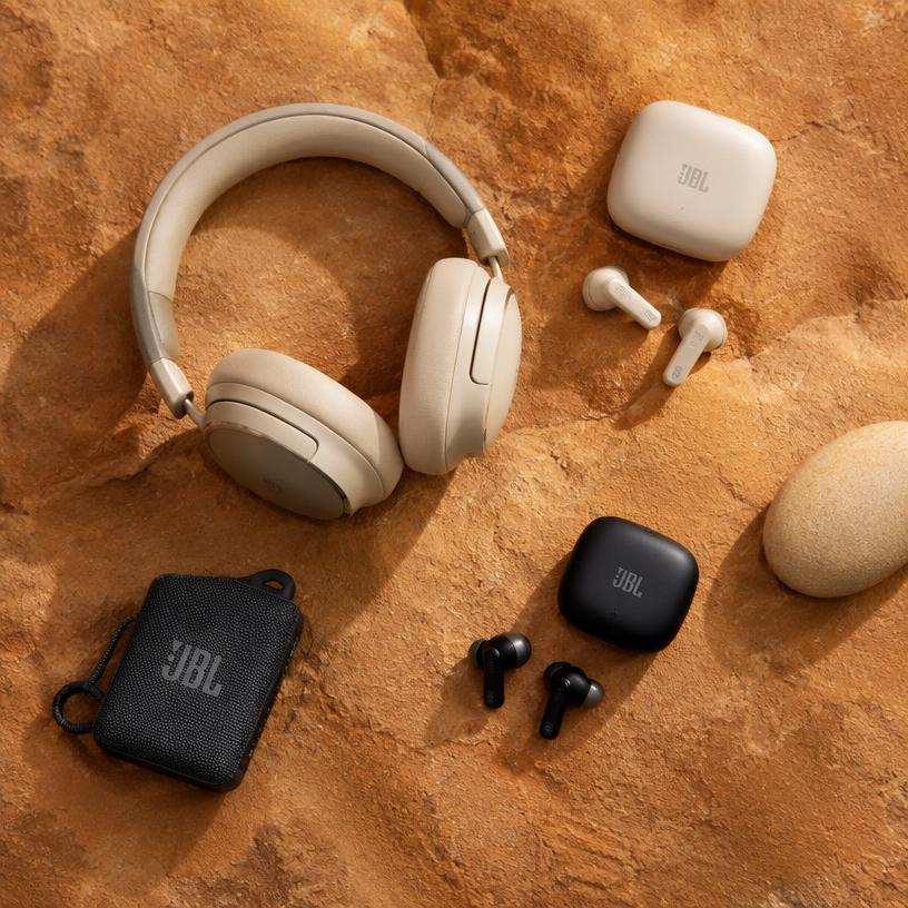Headphones and gadgets on warm sandstone